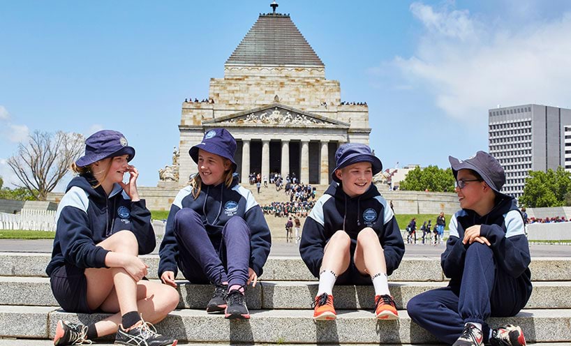 Students sit on the steps in front of the Shrine of Remembrance