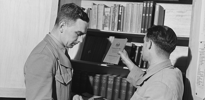 Two RAAF members select publications from the library of the RAAF Educational Service 1944  photographer John Harris Australian War Memorial (VIC1107)