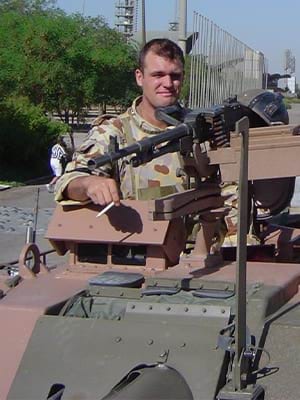 Garth Callender atop an armoured vehicle