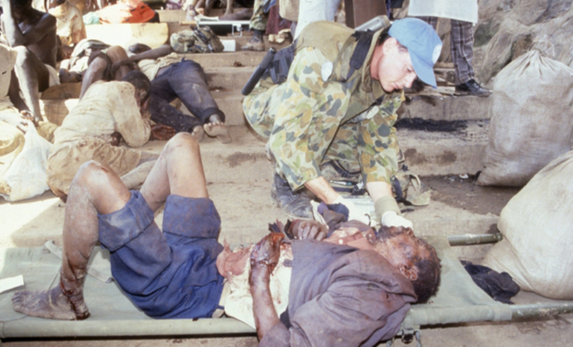 Trooper Jon Church treats a wounded refugee at Kibeho refugee camp April 1995