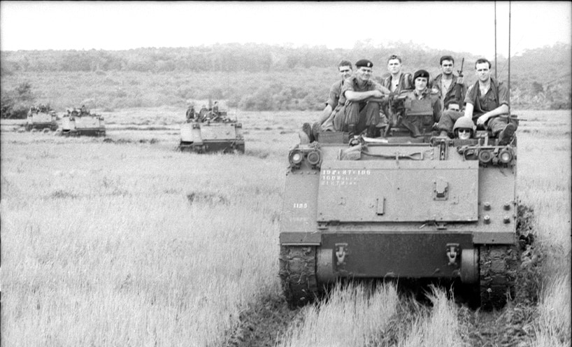 Members of 6th Battalion, the Royal Australian Regiment (6RAR), on the Armoured Personnel Carriers of 1 APC Squadron, wait to return to base after the battle of Long Tan.