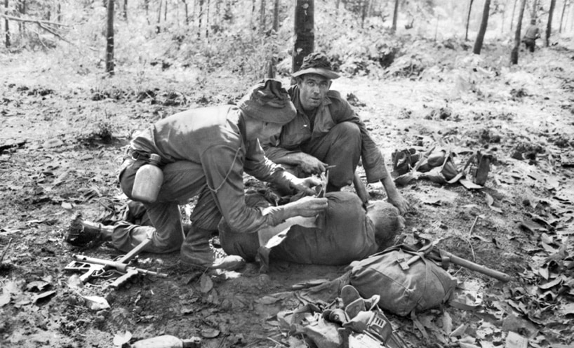 Lance Corporal Georgie Richardson and Sergeant Bob Buick apply first aid to Private Jim Richmond of 11 Platoon. 