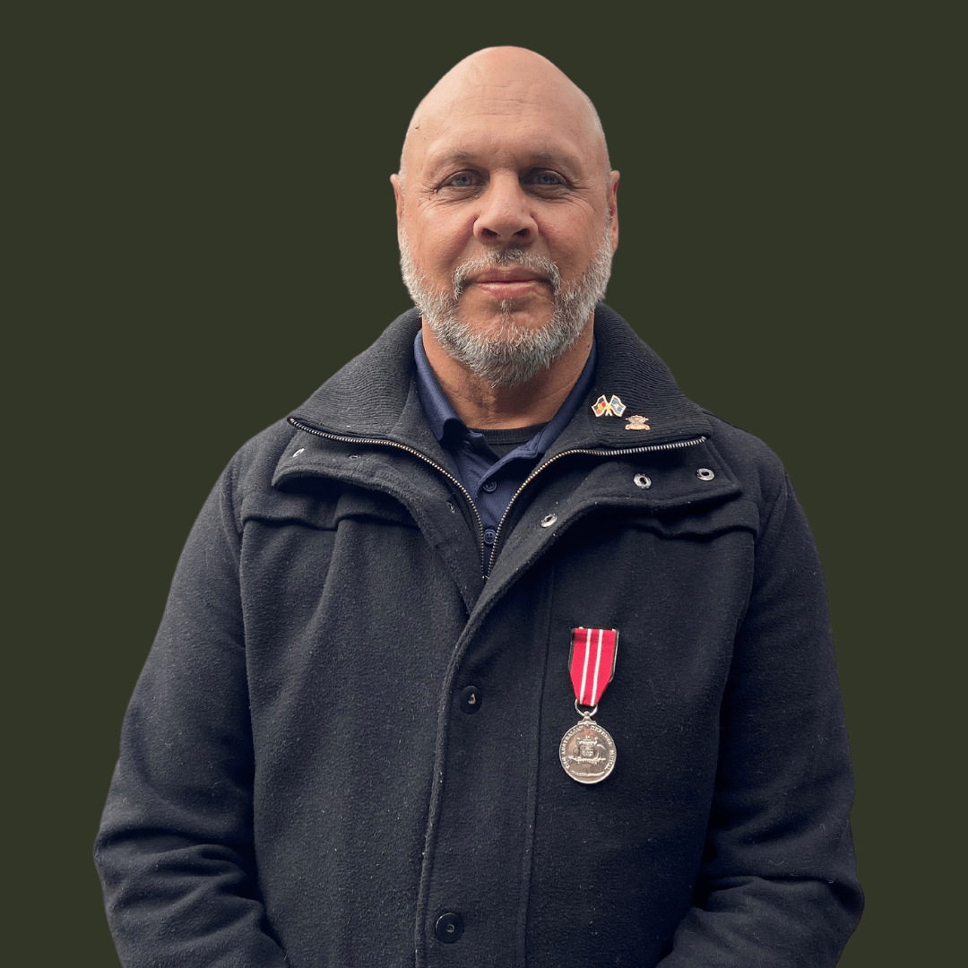 Ngarigo Dunghutti man Rex Solomon looking at the camera wearing his service medals. 