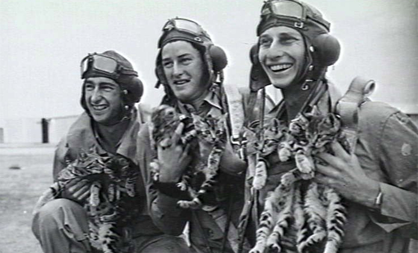 Three Second World War soldiers cuddling their cat mascots