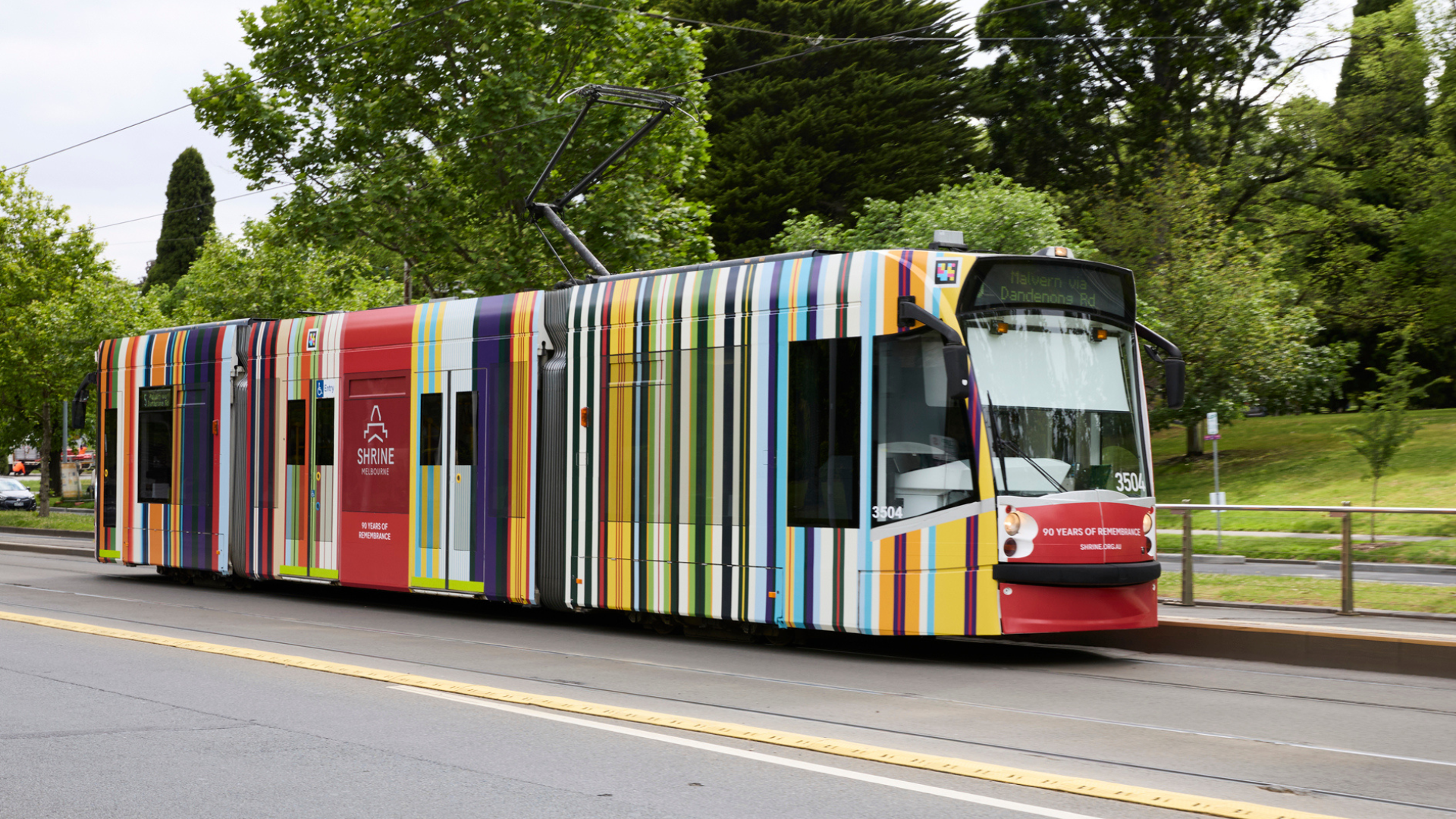 A tram with the Shrine's Ribbon of Reflection artwork