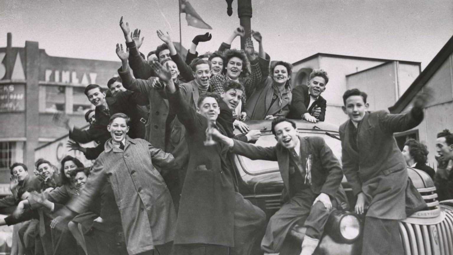 Crowd of women and boys on factory trucks in Elizabeth Street on VP Day 1945. Reproduced courtesy of State Library Victoria H98.101/304 Black and white photograph of a crowd of women and boys celebrating on factory trucks in Elizabeth Street during VP Day 1945